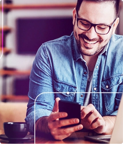 Homem sorrindo utilizando celular